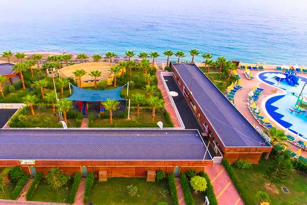 Luftaufnahme des Eftalia Holiday Village mit Meer, Spielplatz, Pool und Hotelgebäuden.
