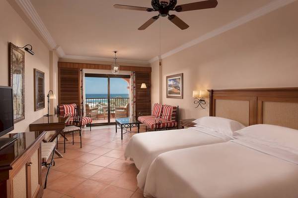 Doppelzimmer im Sheraton Fuerteventura Beach, Golf & Spa Resort mit zwei Betten, Meerblick und Balkon.