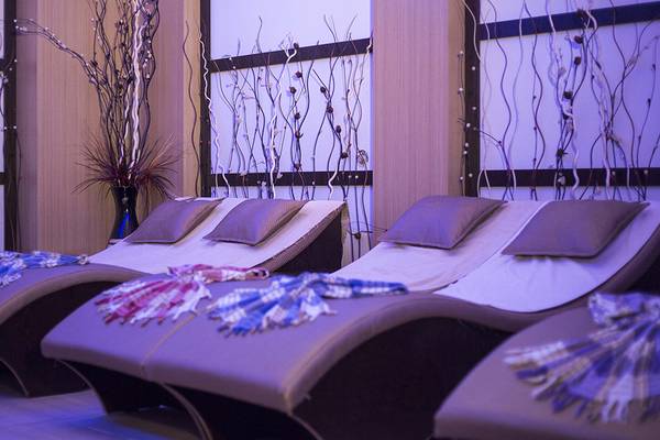 Spa-Lounge im Eftalia Holiday Village mit Liegestühlen, Kissen und Pflanzen.