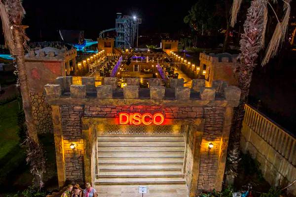 Nachtansicht des Eftalia Holiday Village Disco-Eingangs mit rotem Neonlicht.