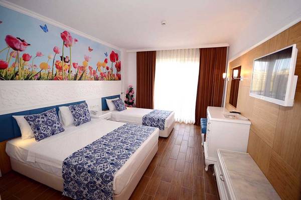 Doppelzimmer im Eftalia Holiday Village mit zwei Betten und blau-weißen Mustern.