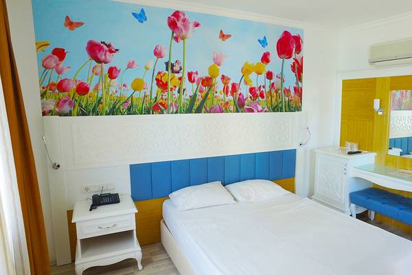 Hotelzimmer mit einer Wand voller bunter Tulpen und Schmetterlinge.