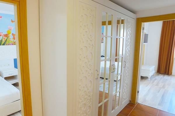 Schlafzimmer im Eftalia Holiday Village mit blumiger Wandgestaltung und Doppelbett.