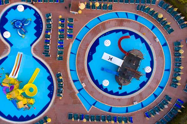 Luftaufnahme des Eftalia Holiday Village mit zwei Pools und vielen Liegen um sie herum.