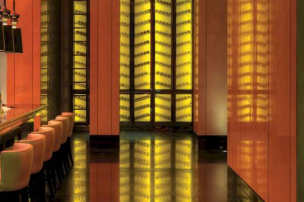 Barbereich des Park Hyatt Abu Dhabi Hotel & Villas mit roten Wänden und gelben Beleuchtung.