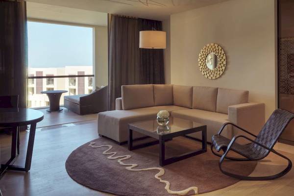 Wohnzimmer des Park Hyatt Abu Dhabi Hotel & Villas mit einem Sofa, einem Tisch und einem Stuhl.