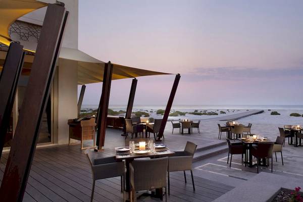 Außenbereich des Park Hyatt Abu Dhabi Hotel & Villas mit Tischen und Stühlen am Strand