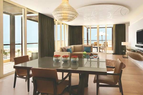 Innenansicht des Wohnzimmers im Park Hyatt Abu Dhabi Hotel & Villas mit Esstisch, Couch, Fernseher und Meerblick.