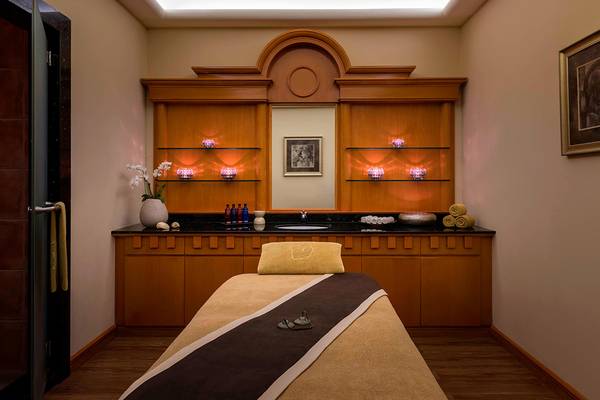Massageraum im Le Royal Meridien Beach Resort & Spa mit Behandlungsliege und Deko