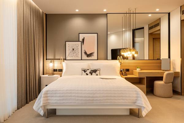 Schlafzimmer im Le Royal Meridien Beach Resort & Spa mit großem Bett, Nachttischen und Schreibtisch.