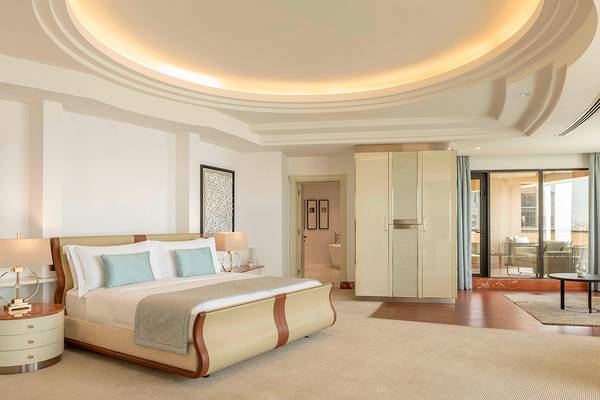 Schlafzimmer im Le Royal Meridien Beach Resort & Spa mit einem großen Bett, zwei Nachttischen und einer Aussicht auf das Meer.