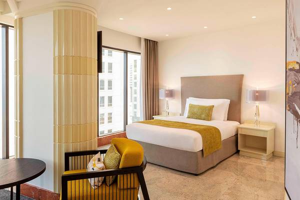 Schlafzimmer im Le Royal Meridien Beach Resort mit großem Bett, Fenstern und Stadtblick