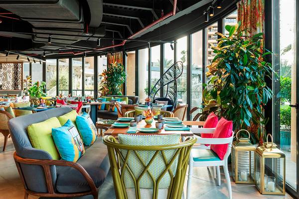 Innenansicht des Restaurants im Le Royal Meridien Beach Resort mit bunten Kissen und Pflanzen.