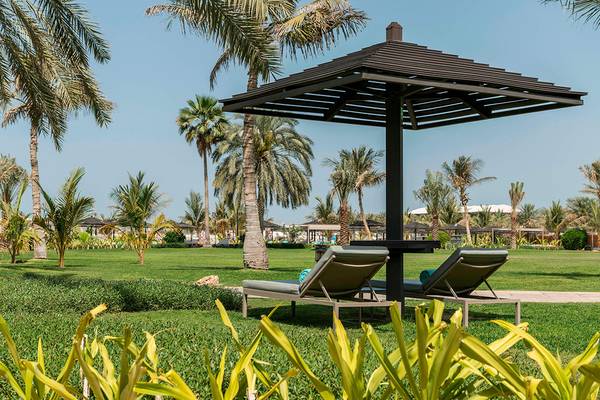Zwei Liegen unter einem Sonnenschirm im Le Royal Meridien Beach Resort & Spa