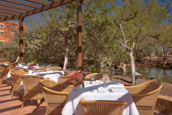 Außenterrasse des Sheraton Fuerteventura Beach, Golf & Spa Resorts mit gedeckten Tischen und Blick auf einen Teich