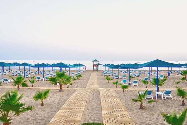 Strand des Paloma Oceana Hotels mit vielen Liegen und Sonnenschirmen