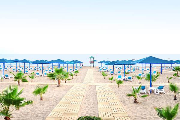 Strandbereich des Paloma Oceana Hotels mit vielen Sonnenschirmen und Liegen am Meer