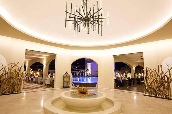 Eingangsbereich des Paloma Oceana Hotels mit zentralem Brunnen und einer beeindruckenden Deckenleuchte.