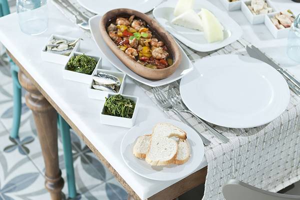 Tisch mit verschiedenen Speisen im Paloma Oceana Hotel, darunter gebratene Garnelen, Käse, Oliven und Brot.