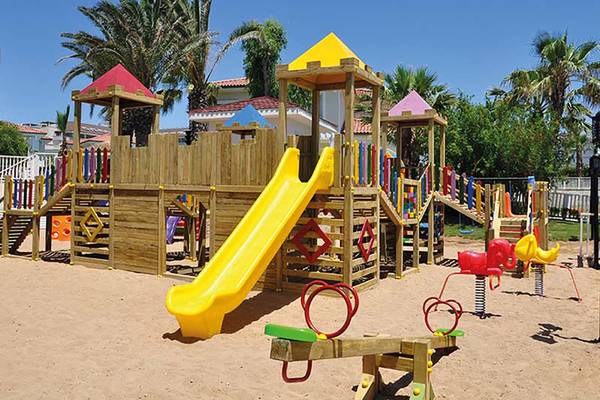 Foto eines bunten Spielplatzes im Paloma Oceana Hotel mit einer großen gelben Rutsche und verschiedenen Spielgeräten.