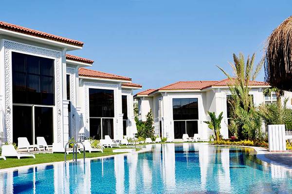 Außenbereich des Paloma Oceana Hotels mit Swimmingpool und Loungeliegen.