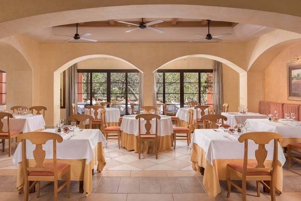 Innenansicht des Restaurants im Sheraton Fuerteventura Beach, Golf & Spa Resort mit gedeckten Tischen und Stühlen.
