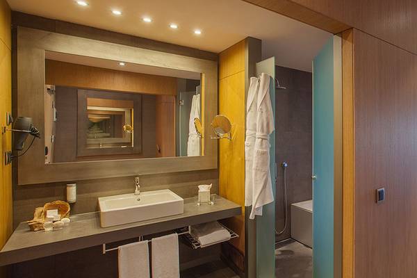 Das Badezimmer im Lopesan Baobab Resort mit einer Dusche, einem Waschbecken und einem Spiegel.