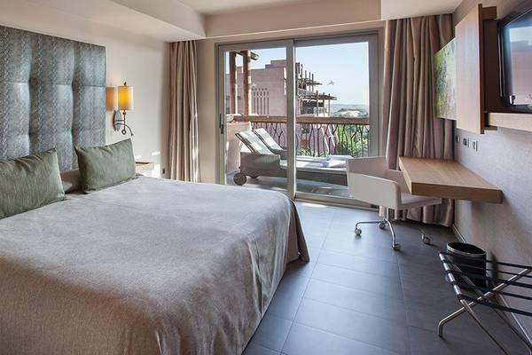 Doppelbettzimmer im Lopesan Baobab Resort mit Balkon und Schreibtisch.