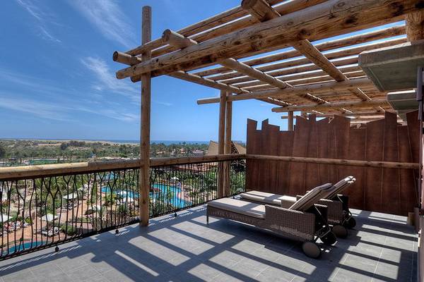 Ausblick vom Balkon des Lopesan Baobab Resorts auf einen Pool und eine Landschaft.