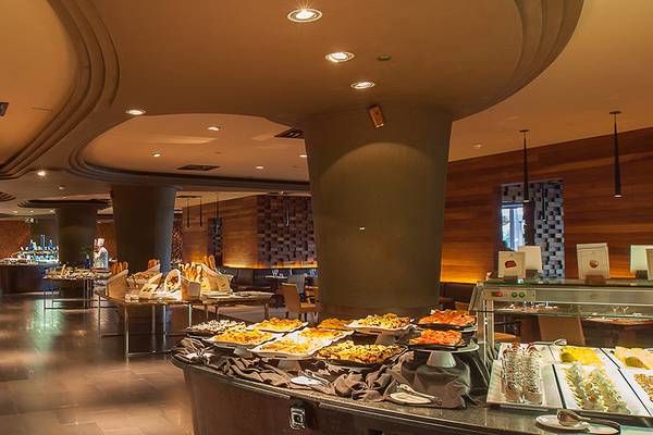 Innenansicht des Restaurants im Lopesan Baobab Resort mit vielen Speisen und Holzwänden.