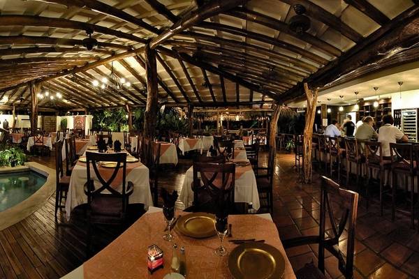 Innenansicht des Restaurants im Jardin del Eden Boutique Hotel mit gedeckten Tischen und Sitzgelegenheiten.