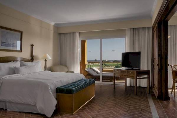 Hotelzimmer mit Bett, Fernseher und Balkon im Cascades Golf Resort Spa & Thalasso