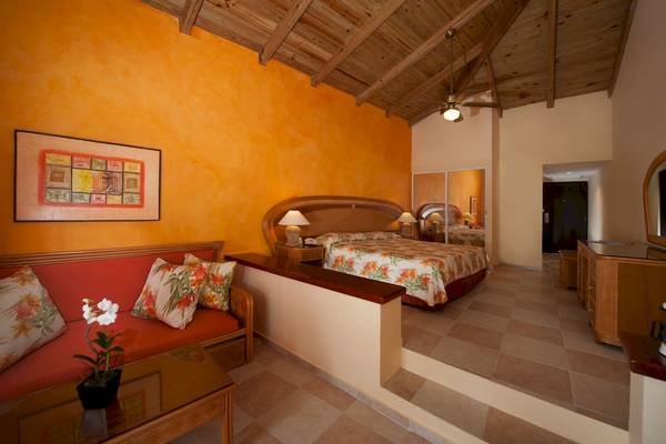 Hotelzimmer im Caribe Deluxe Princess Hotel mit farbenfrohem Design und tropischen Mustern.