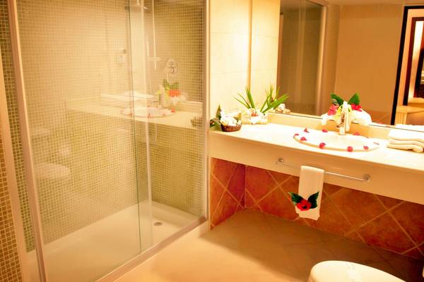 Badezimmer im Caribe Deluxe Princess Hotel mit einer Dusche, Waschbecken und Toilette.