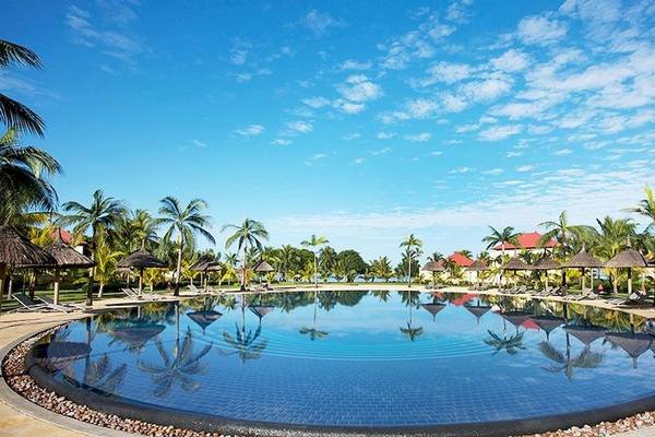 Poolbereich des Tamassa Bel Ombre Hotels mit Sonnenliegen und Palmen