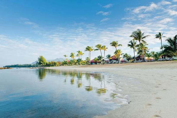 Strand des Tamassa Bel Ombre Hotels mit Palmen und Wasser