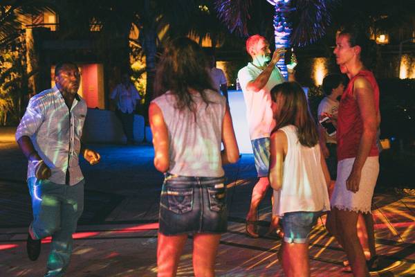 Feiernde Personen auf der Tanzfläche im Freien im Hotel Tamassa Bel Ombre bei Nacht.