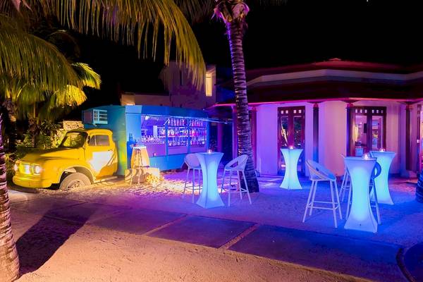 Nachtbar des Tamassa Bel Ombre Hotels mit gelbem Truck und blauer Beleuchtung.