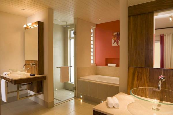 Ein Badezimmer im Tamassa Bel Ombre Hotel mit einer Badewanne und einem Waschbecken.