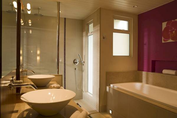 Badezimmer im Tamassa Bel Ombre Hotel mit zwei Waschbecken und einer Badewanne.