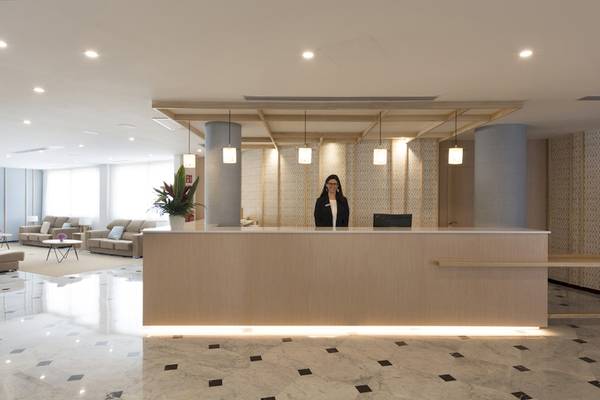 Empfangsbereich des HSM Golden Playa Hotels mit Rezeptionistin und modernen Möbeln
