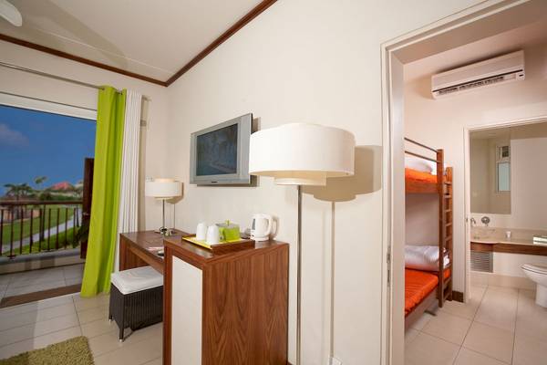 Zimmer im Tamassa Bel Ombre mit Doppelstockbett und Arbeitsbereich.