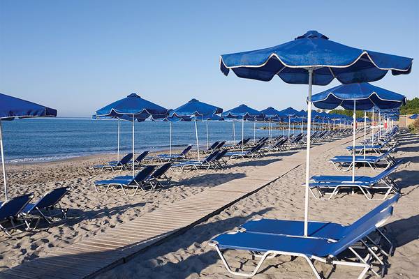 Strand des Porto Bello Royal Hotels mit blauen Sonnenschirmen und Liegestühlen