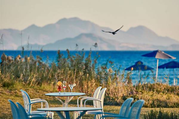 Außenterrasse des Porto Bello Royal Hotels mit Blick auf das Meer und eine Vogel in Flug