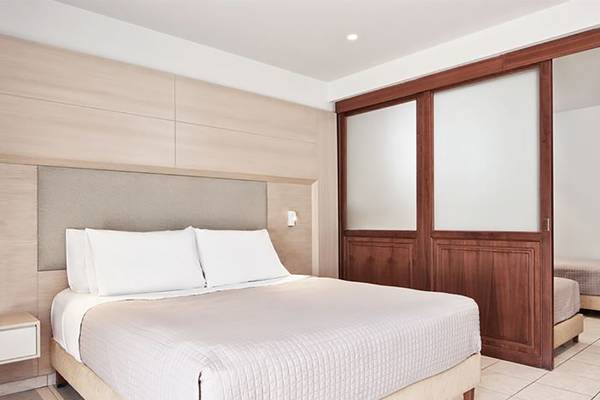Schlafzimmer im Porto Bello Royal Hotel mit Bett, Kissen und Holzschrank