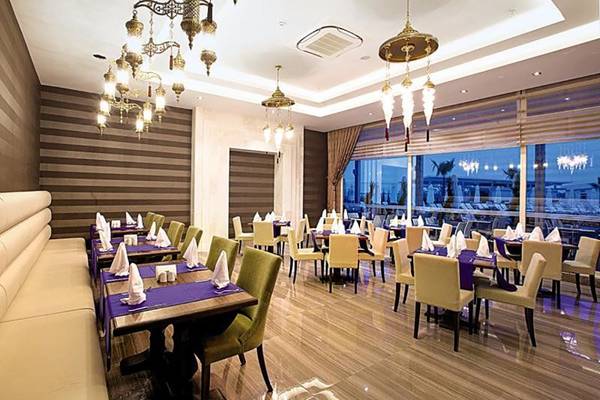 Restaurant des Diamond Elite Hotel & Spa mit gepolsterten Bänken und gedeckten Tischen.