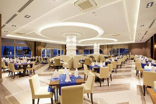 Restaurant des Diamond Elite Hotel & Spa mit vielen gedeckten Tischen und Stühlen.
