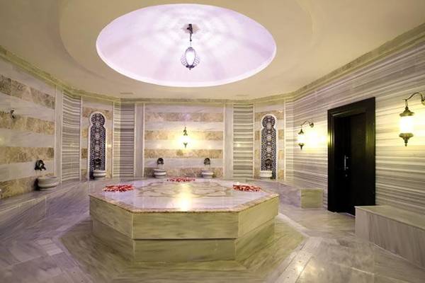 Innenbereich des Diamond Elite Hotel & Spa mit Marmorwänden und einem zentralen Badezuber.