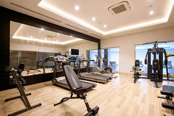 Innenansicht des Fitnessstudios im Diamond Elite Hotel & Spa mit verschiedenen Trainingsgeräten und Spiegeln.