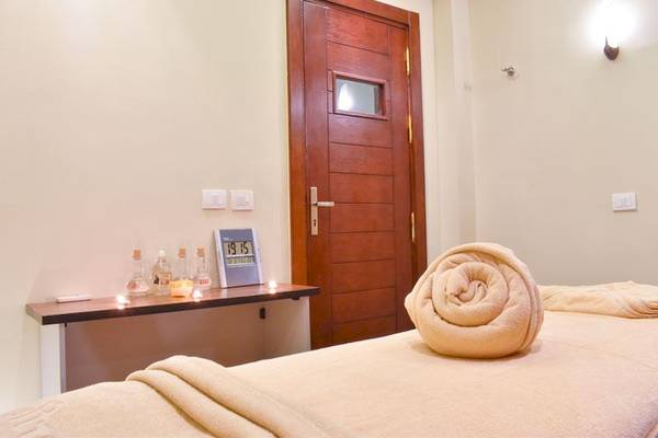 Massage Zimmer im Parrotel Beach Resort mit vorbereitetem Bett und Kerzenlicht.